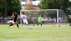 three women playing soccer game